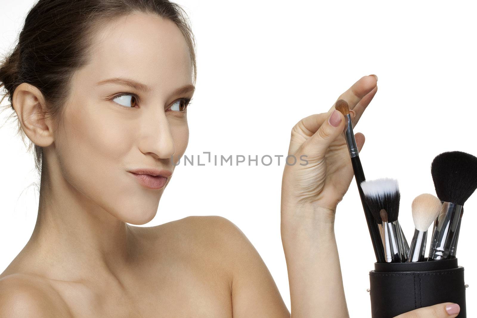 Portrait of a young girl posing with brushes and smiling. Isolated on white background