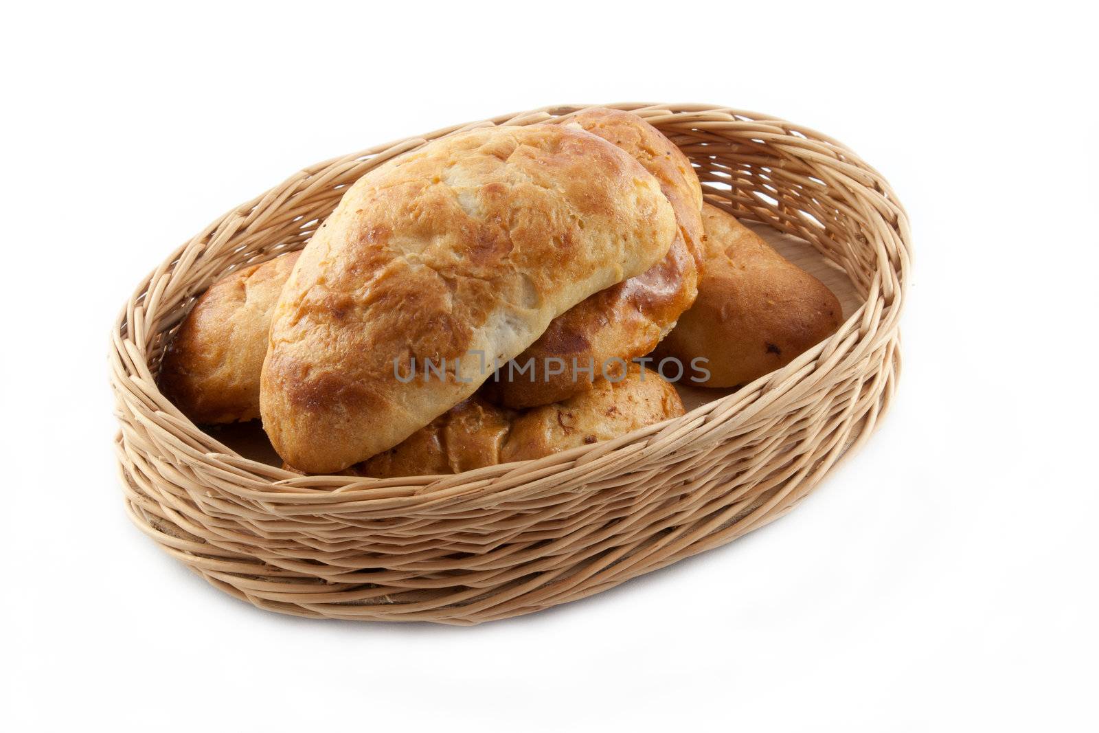 Homemade pasty in wicker basket on white background