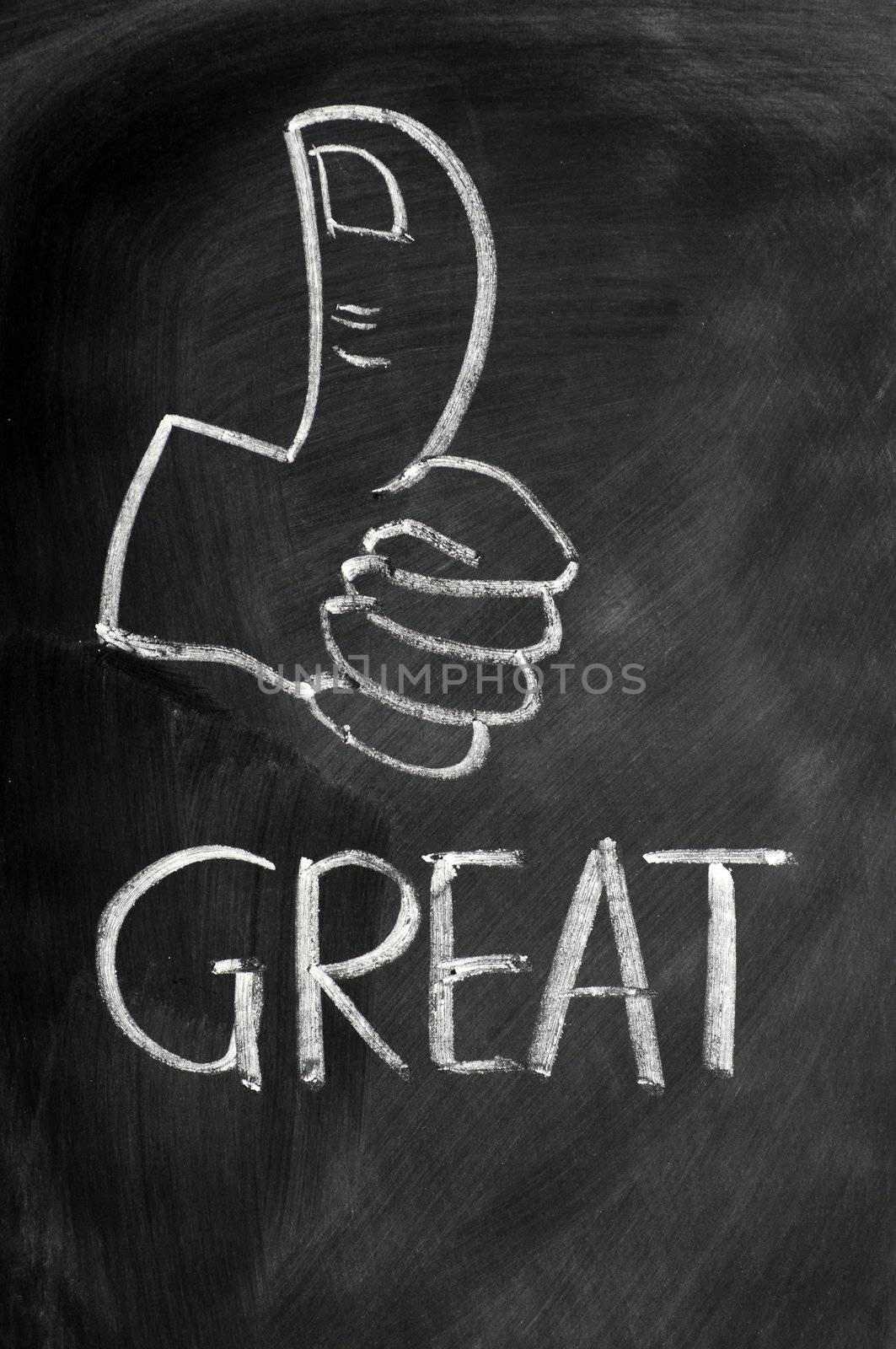 Thumb up with the word great drawn in chalk on a blackboard