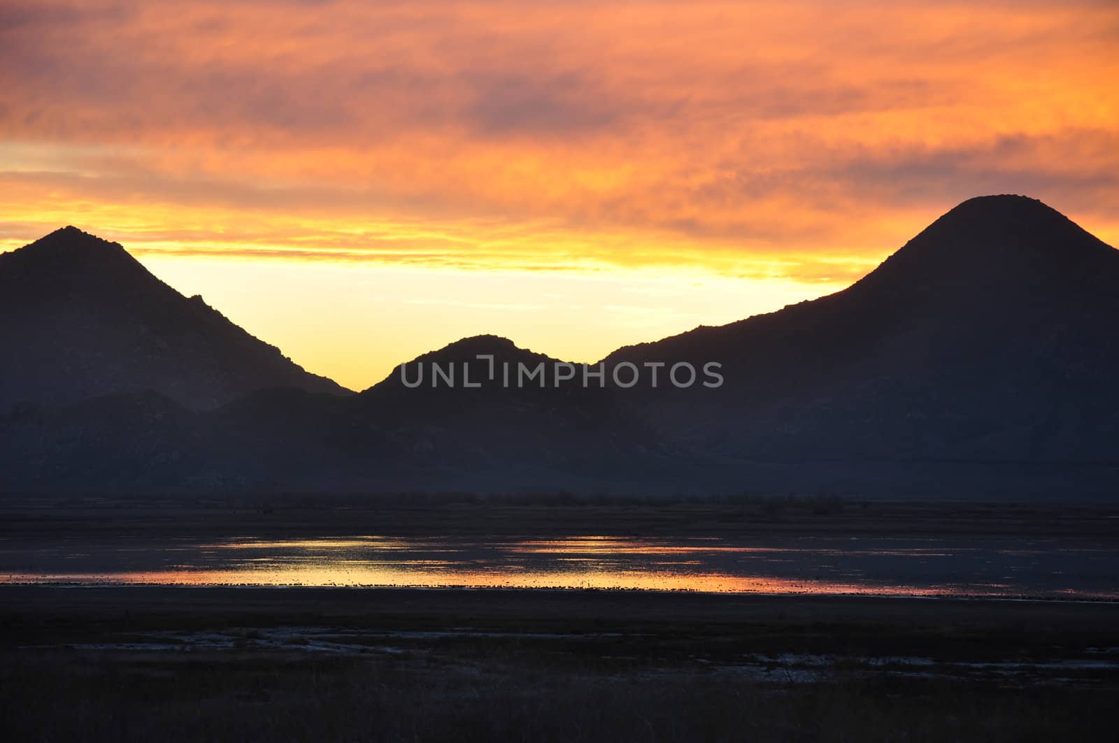 The hills around Mystic Lake in Southern California are silhouetted by the bright sunset.