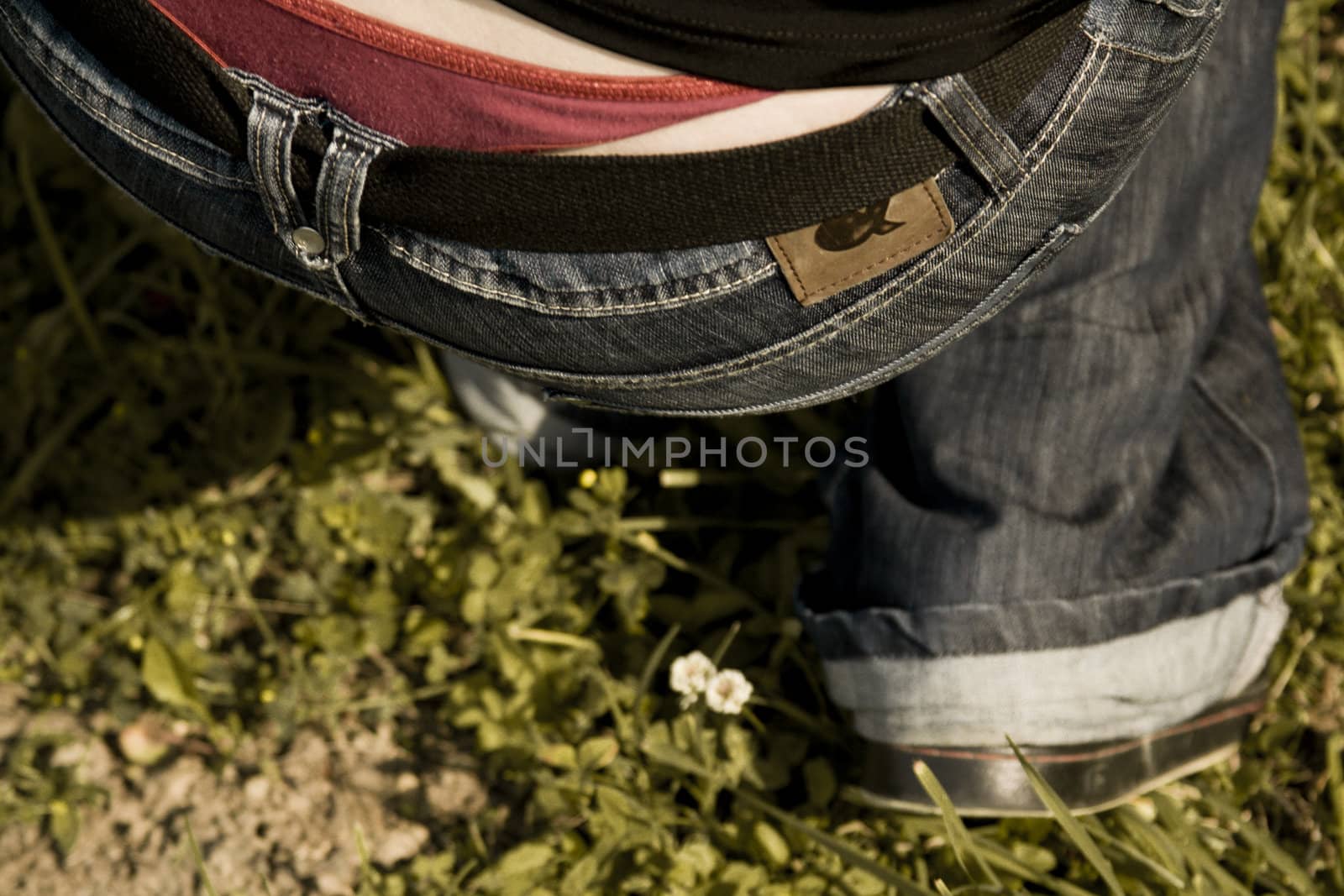 Close-up of a girl kneeing down in red underwear and jeans. by domencolja