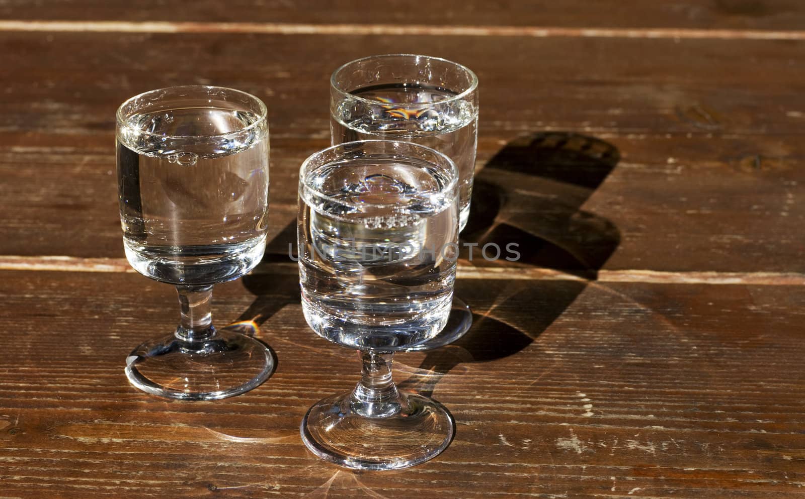 Photo of three small glasses full of spirit alcohol