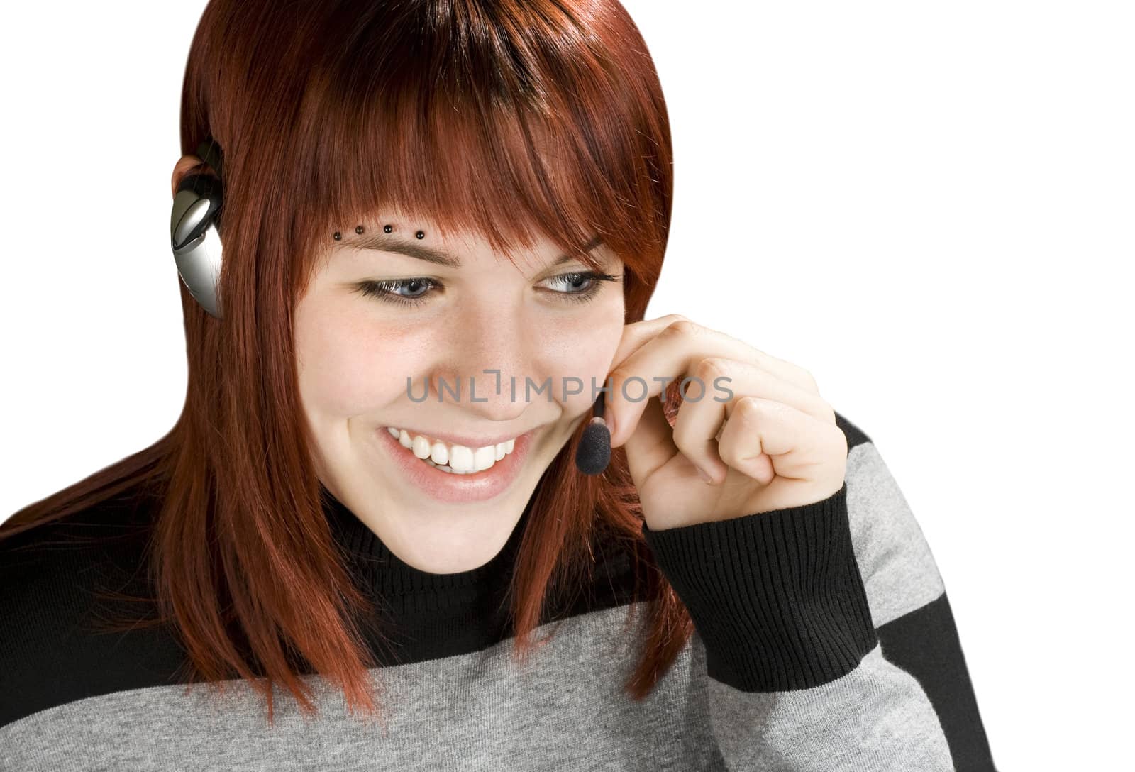 Beautiful smiling girl at a call center answering with a handset.

Studio shot.