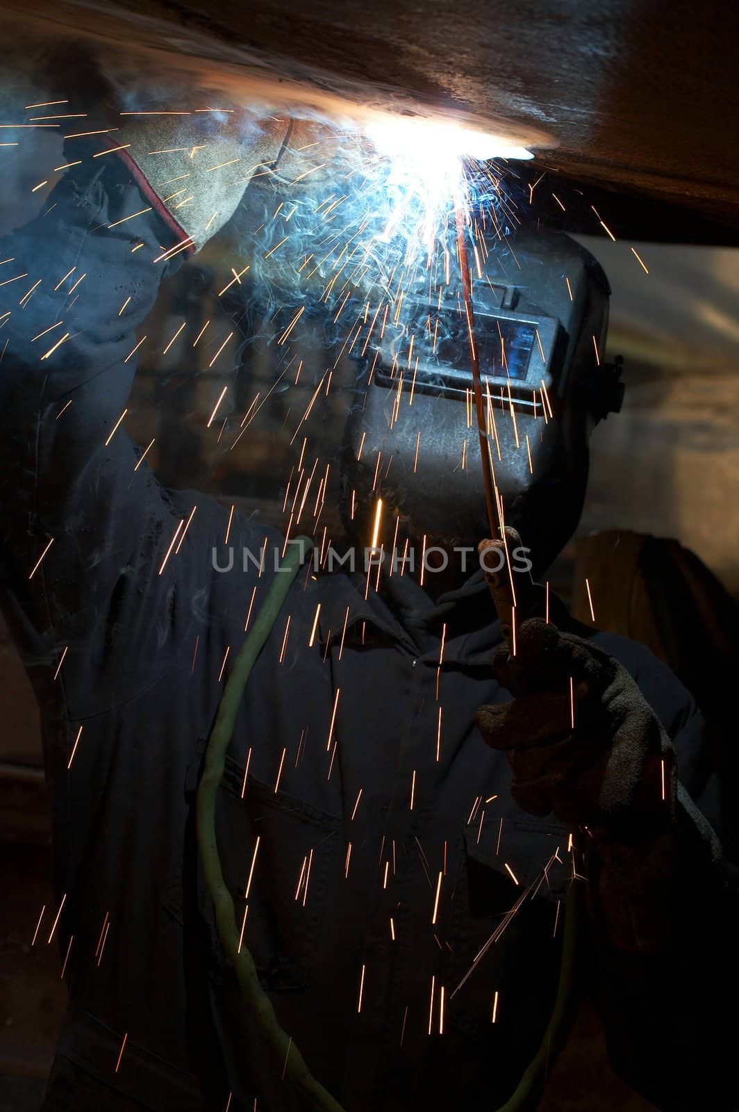 a welder working at shipyard under vessel