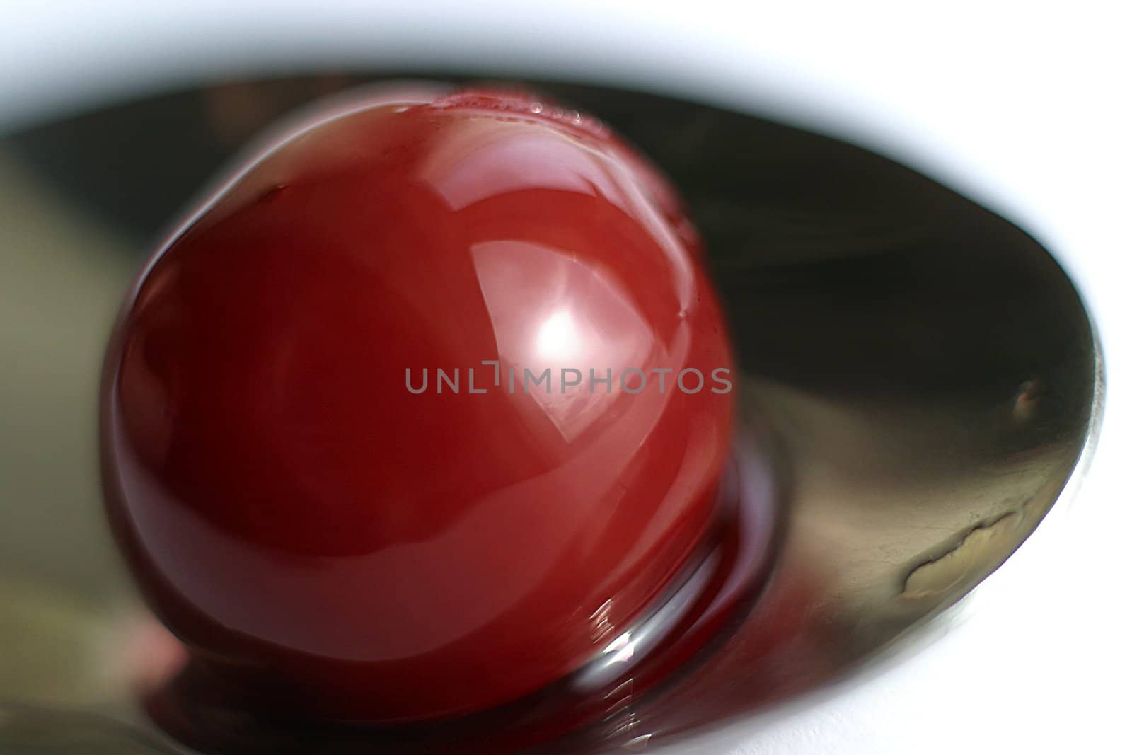 Berry of a cherry in a spoon with juice