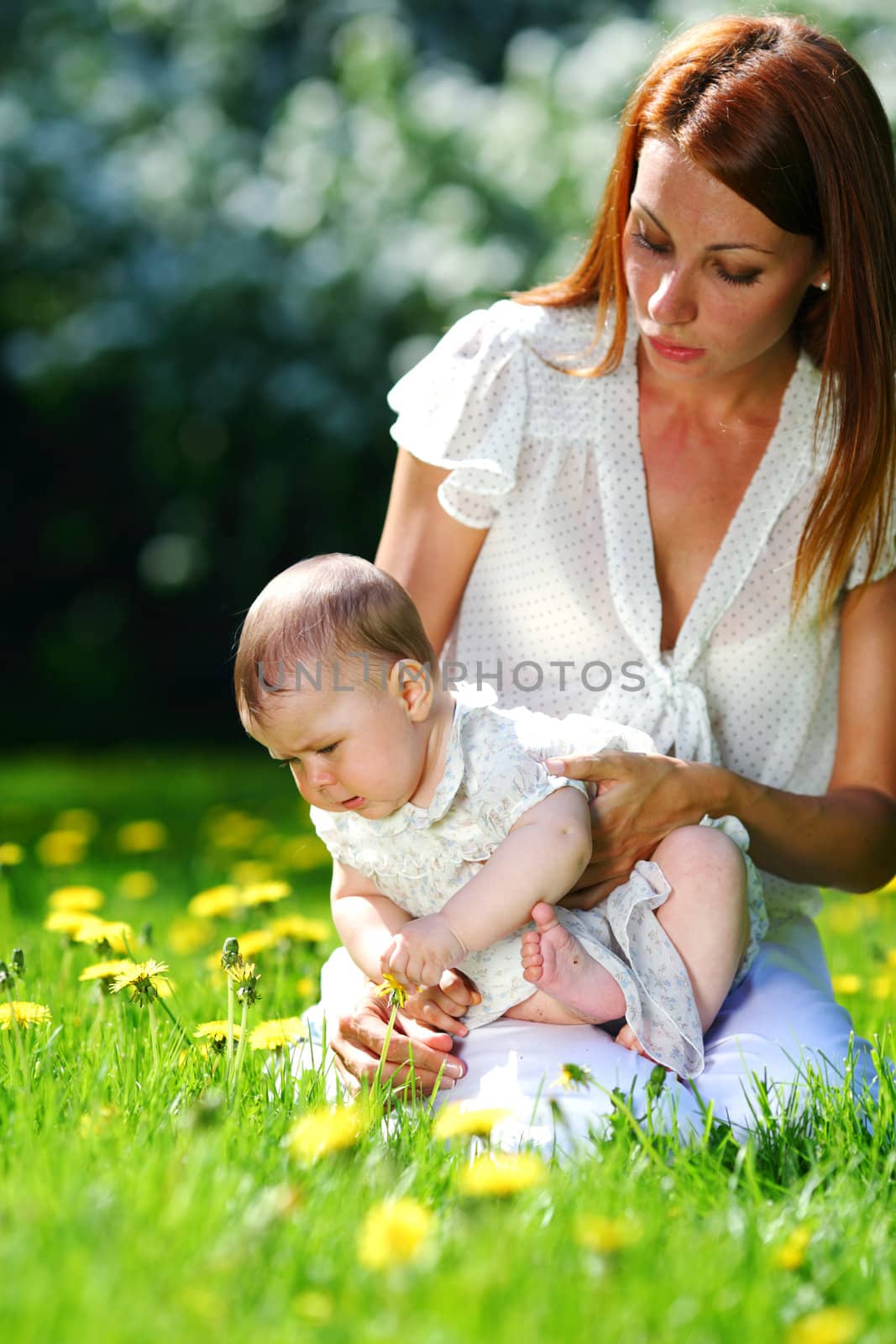 Mother and daughter on the green grass by Yellowj