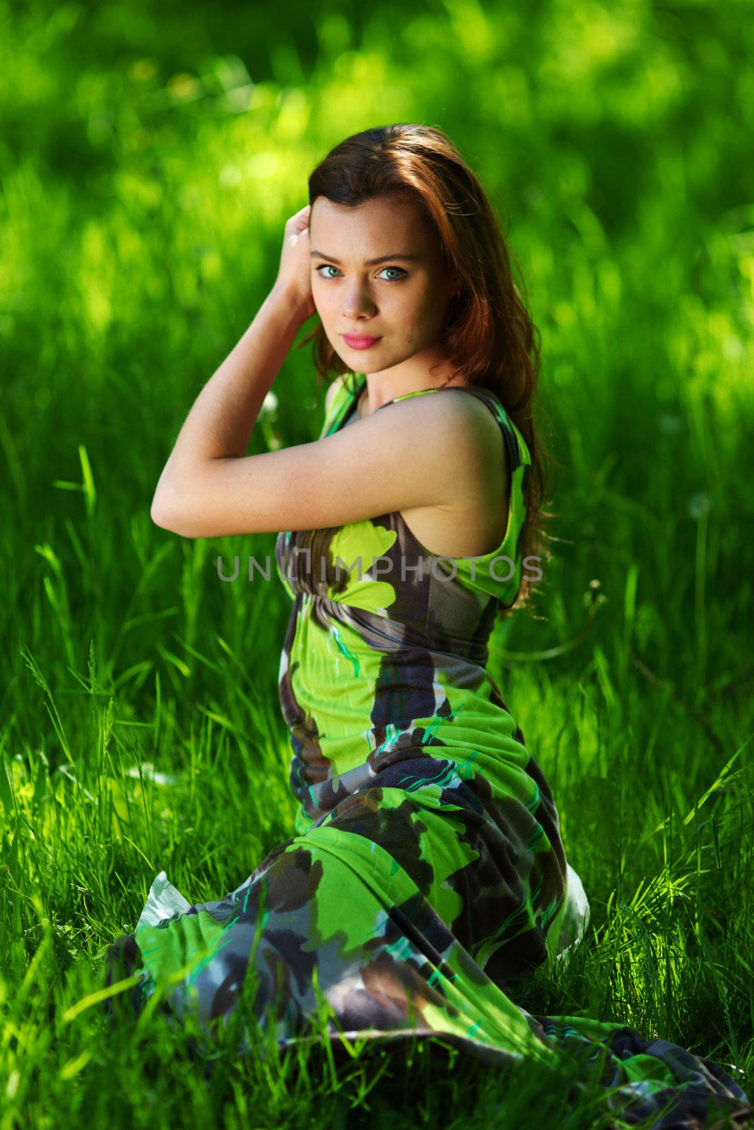 brunette sitting on green grass by Yellowj