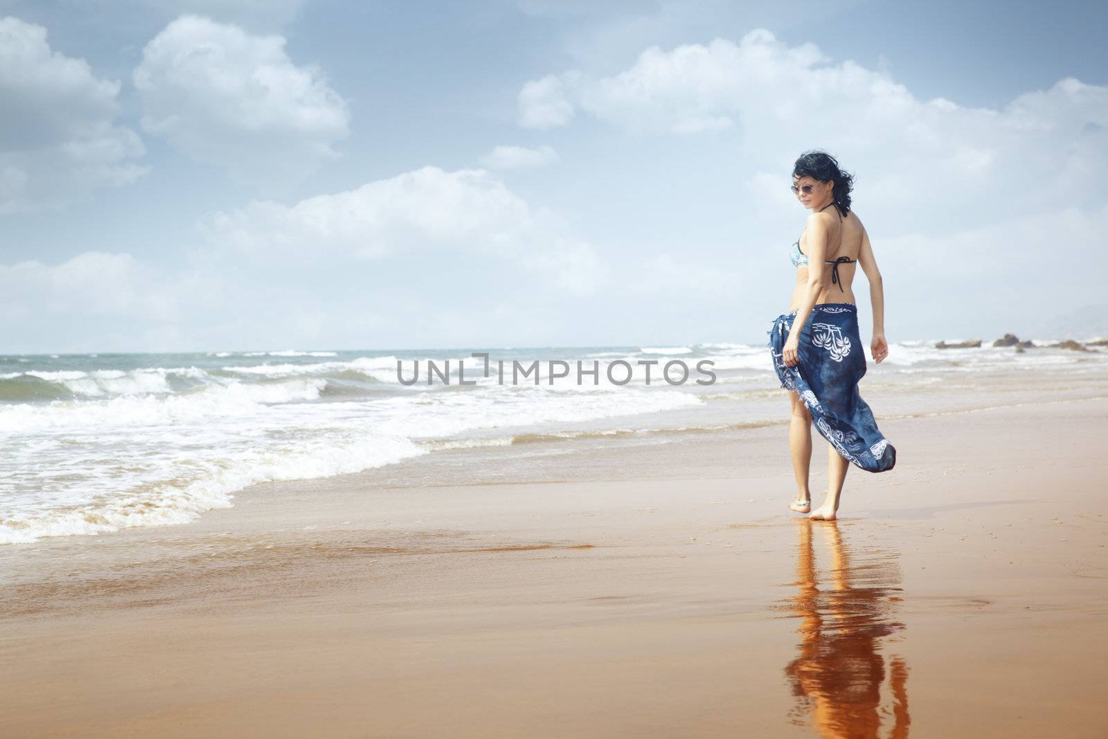 Smiling lady walking at the paradise beach. Natural light and colors