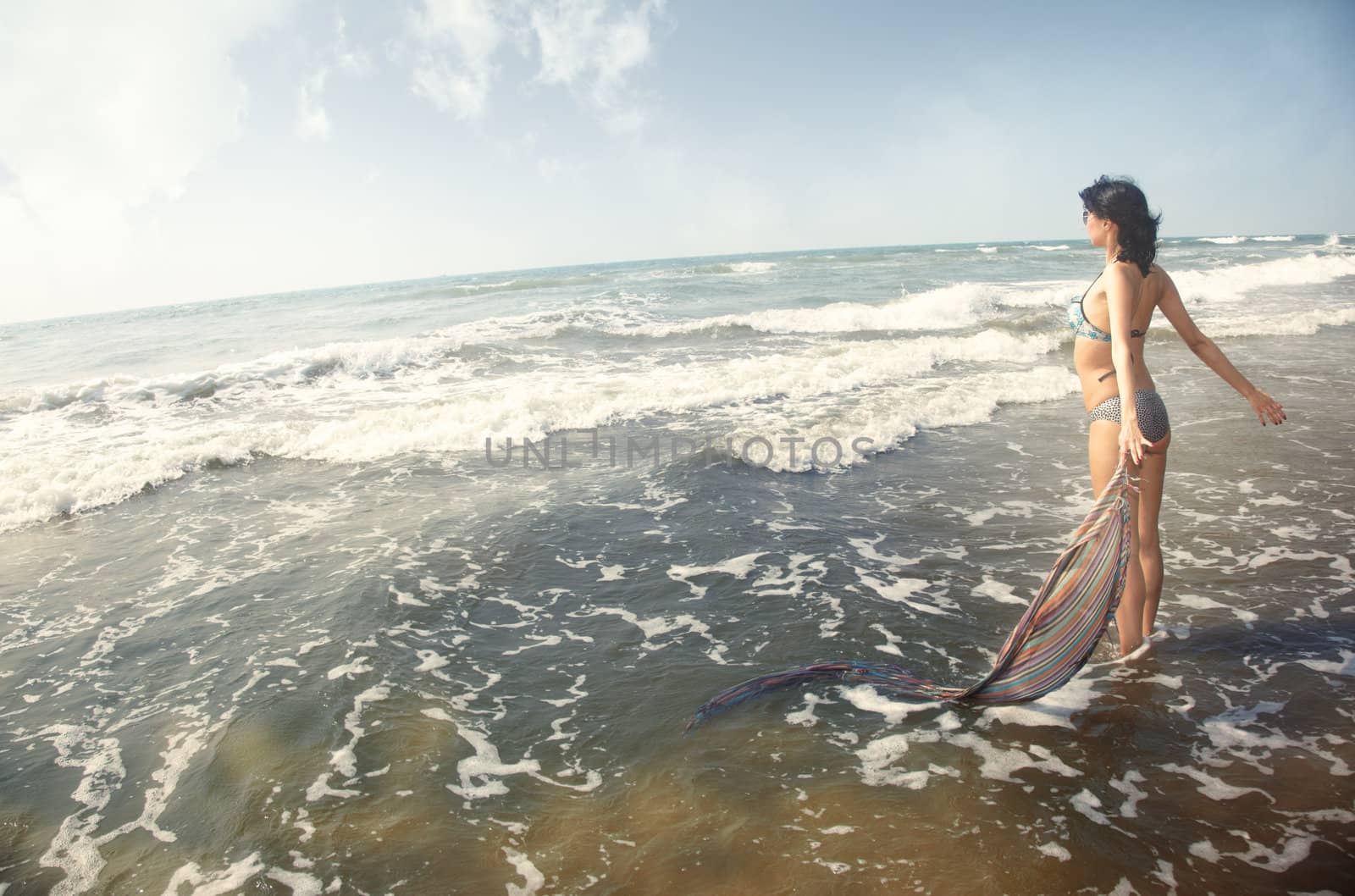 Happy brunette lady stands at summer beach