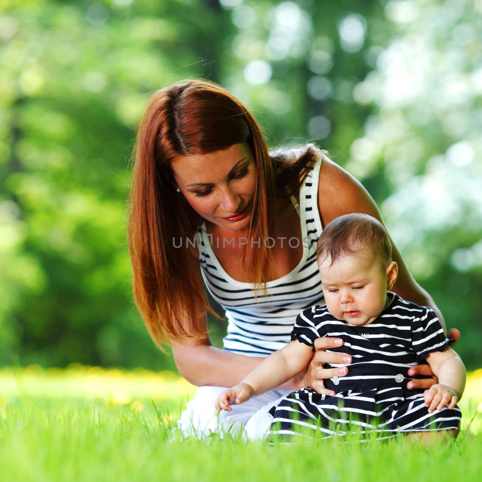 Happy mother and daughter on the green grass