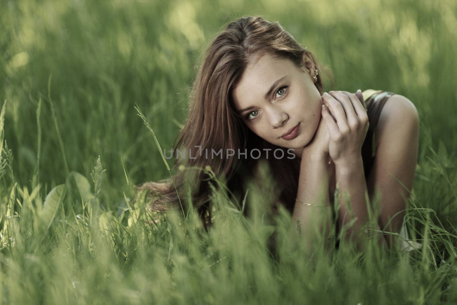 brunette lying on green grass by Yellowj