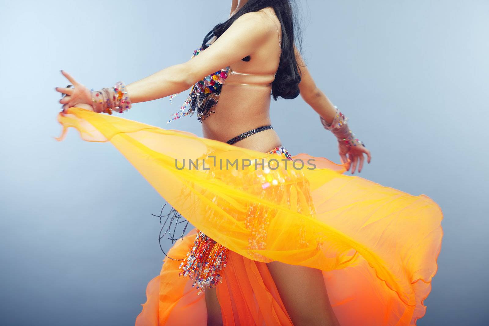 Body part of the woman dancing belly dance in traditional costume