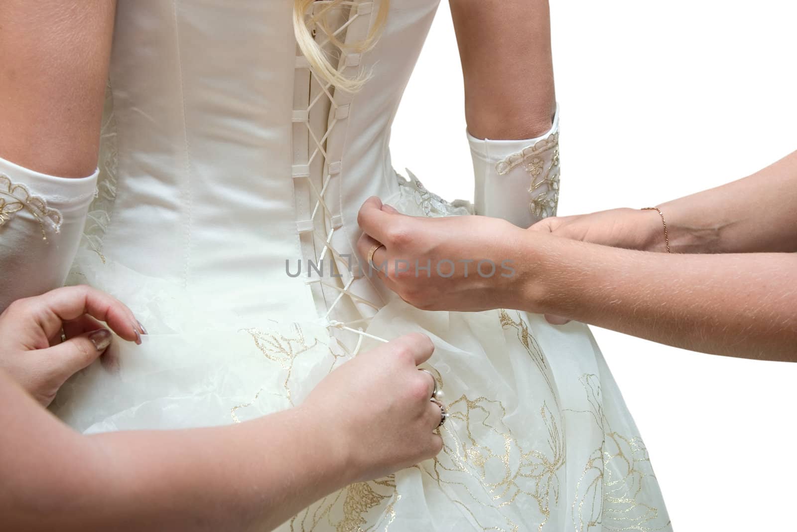 Girlfriends of the bride help to put on a wedding dress