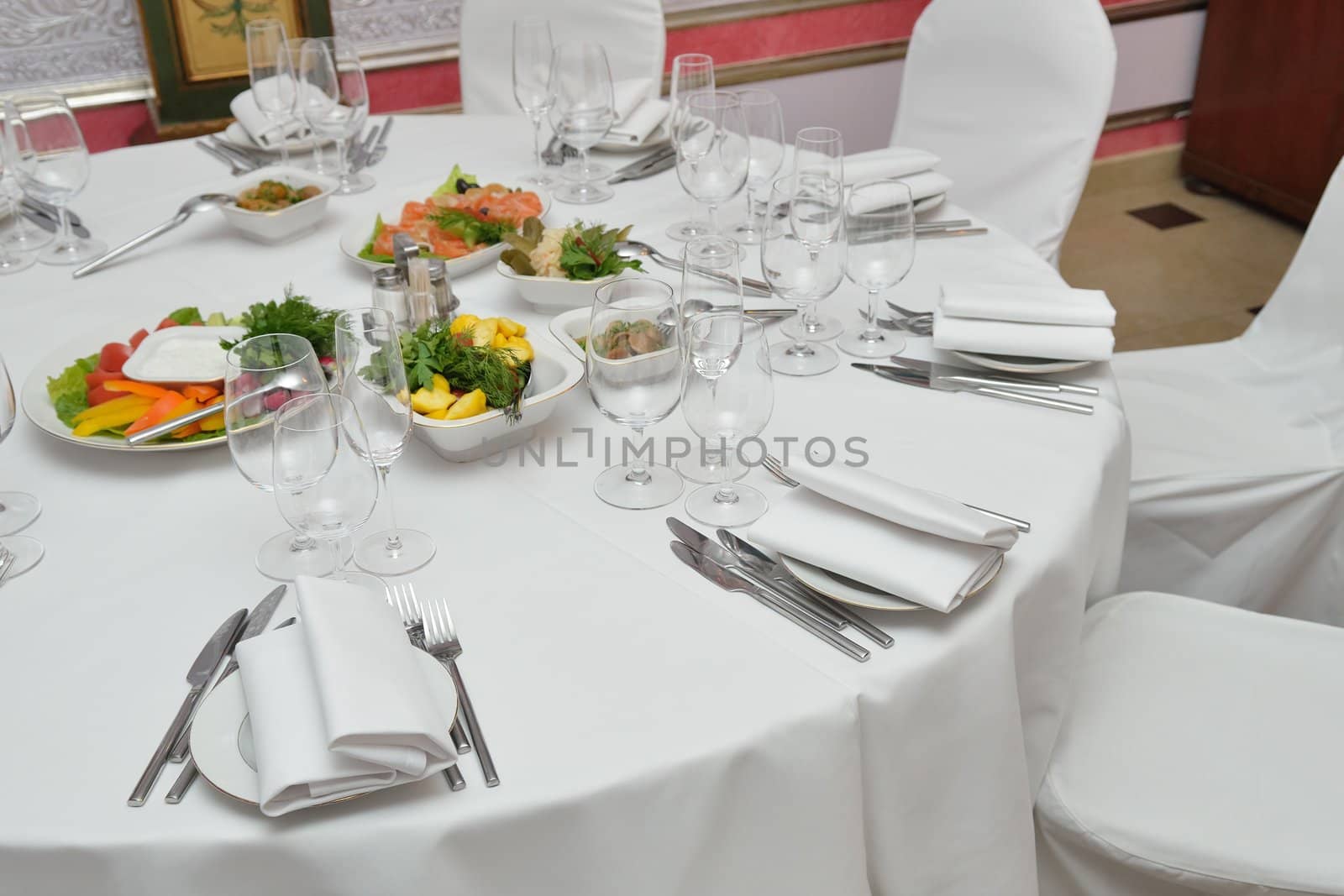 Served table with appetizers, dishes and glasses.