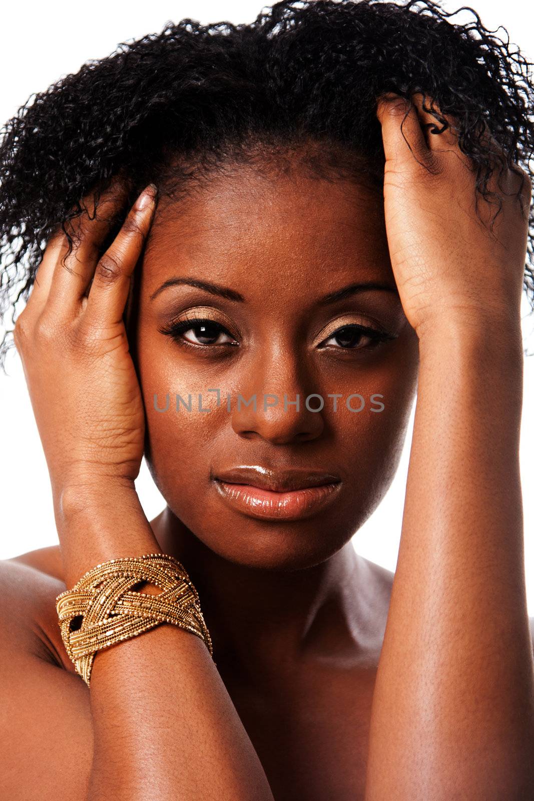 Face of a beautiful African woman with great skin holding hands in curly hair and bracelet around arm, isolated.