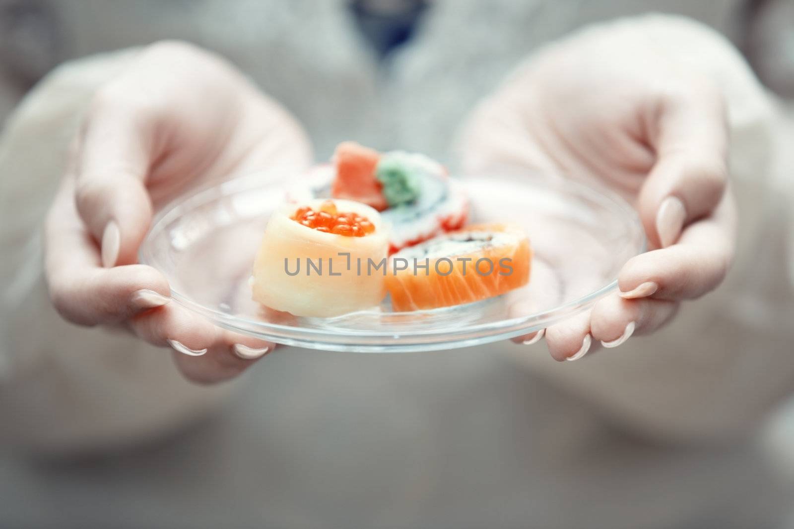 Human hands holding place with sushi