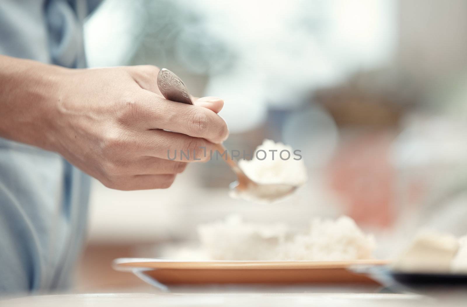 Woman hand holding spoon with rice-milk