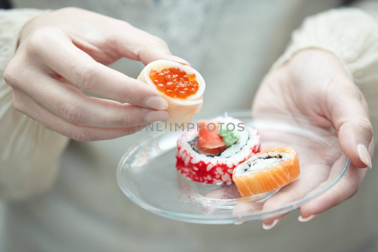 Human hands holding place with sushi