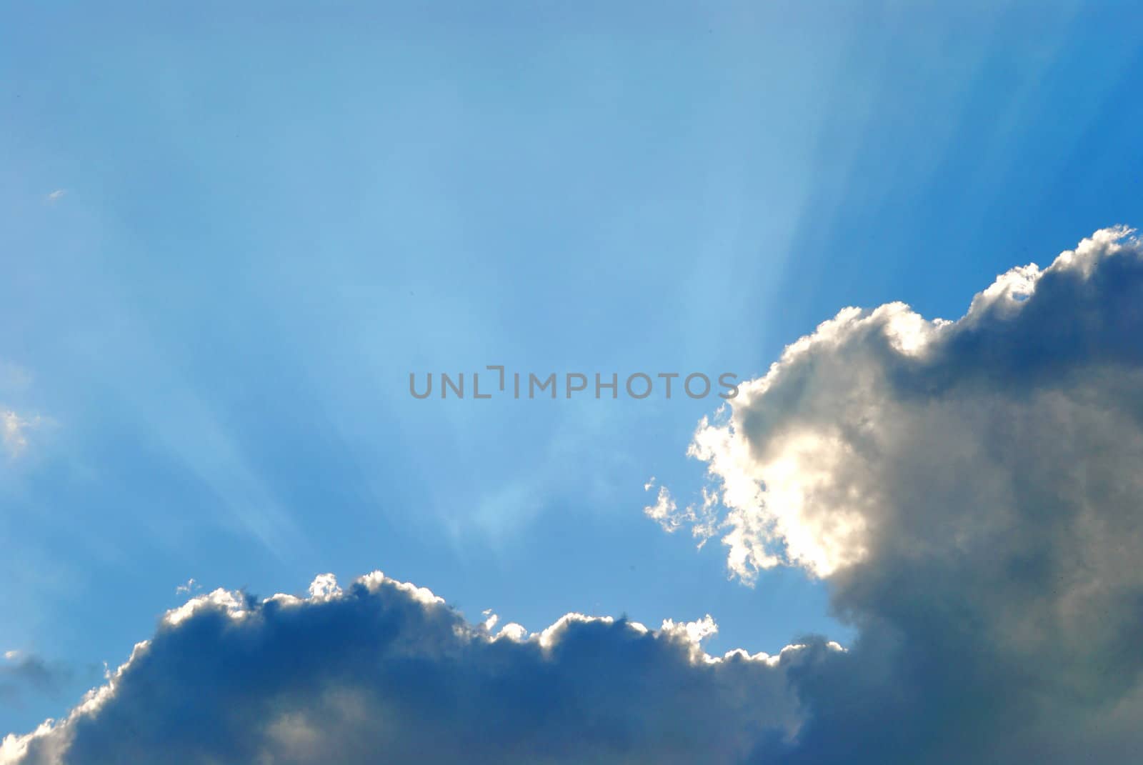 sun hiding behind the dark white-bluish cloud sparkling a beautiful glow
