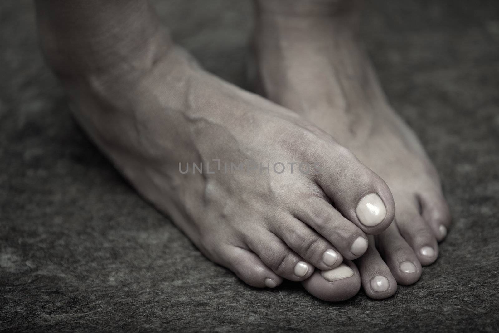 Feet of adult woman on a dark background