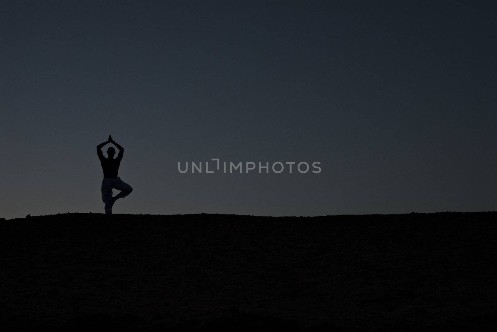 Male model practicing Yoga on the beach at sunset, Red Sea, Egypt