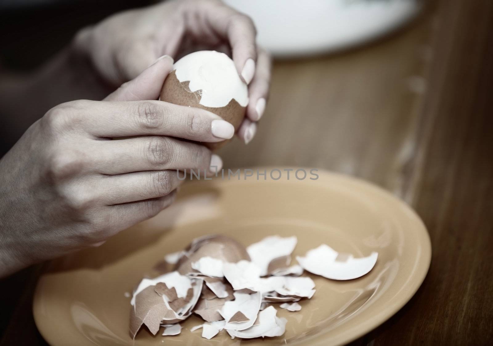 Human hand preparing boiled egg