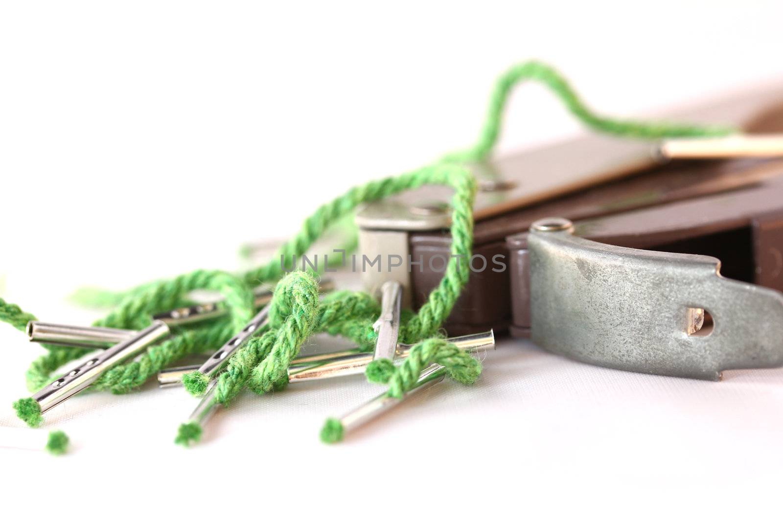 A hole punch sits with some string document ties.