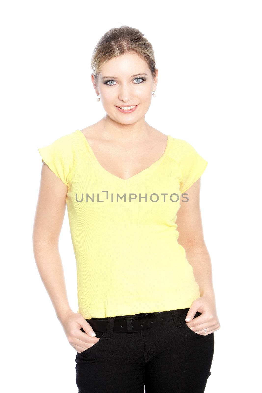 Casual smiling young woman standing looking at the camera with her hands in her pockets, isolated on white