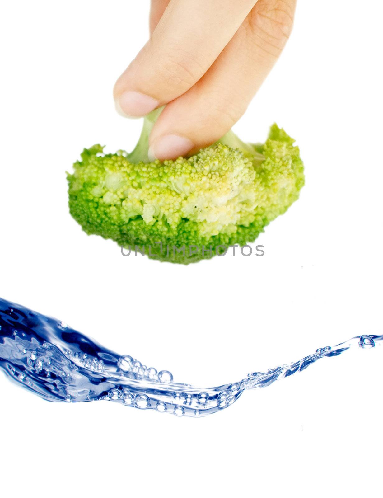 Clusters of broccoli falling into water