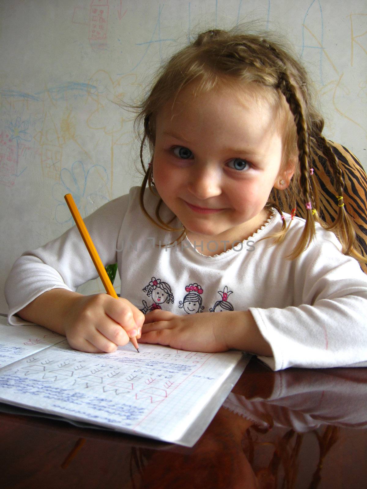 the little girl with nice hair-do learning her  home tasks