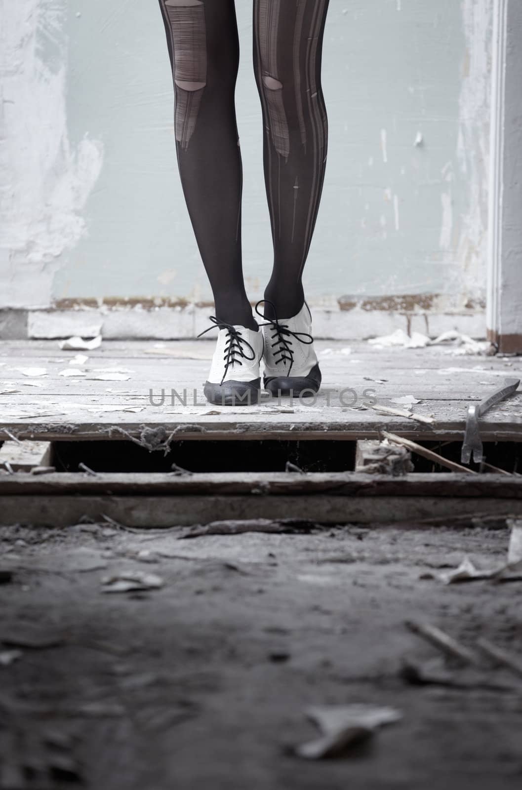 Human legs in stylish shoes standing in the ruined dirty room