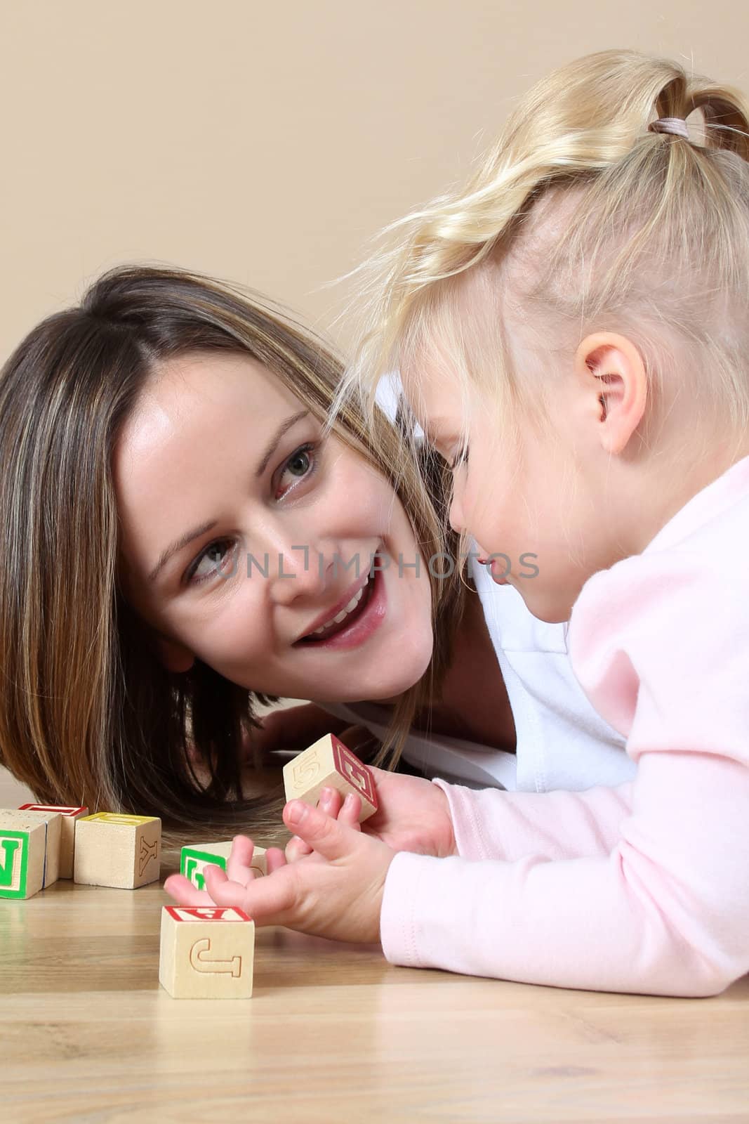 Mother and daughter playing with alphabet building blocks