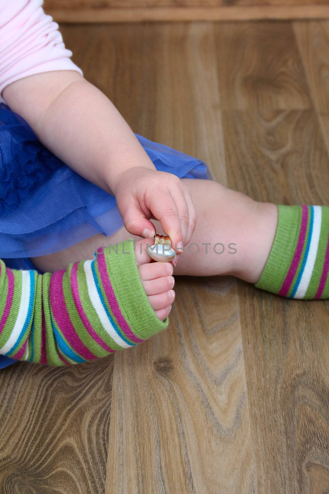 Little girl playing with a gold ring on her toe
