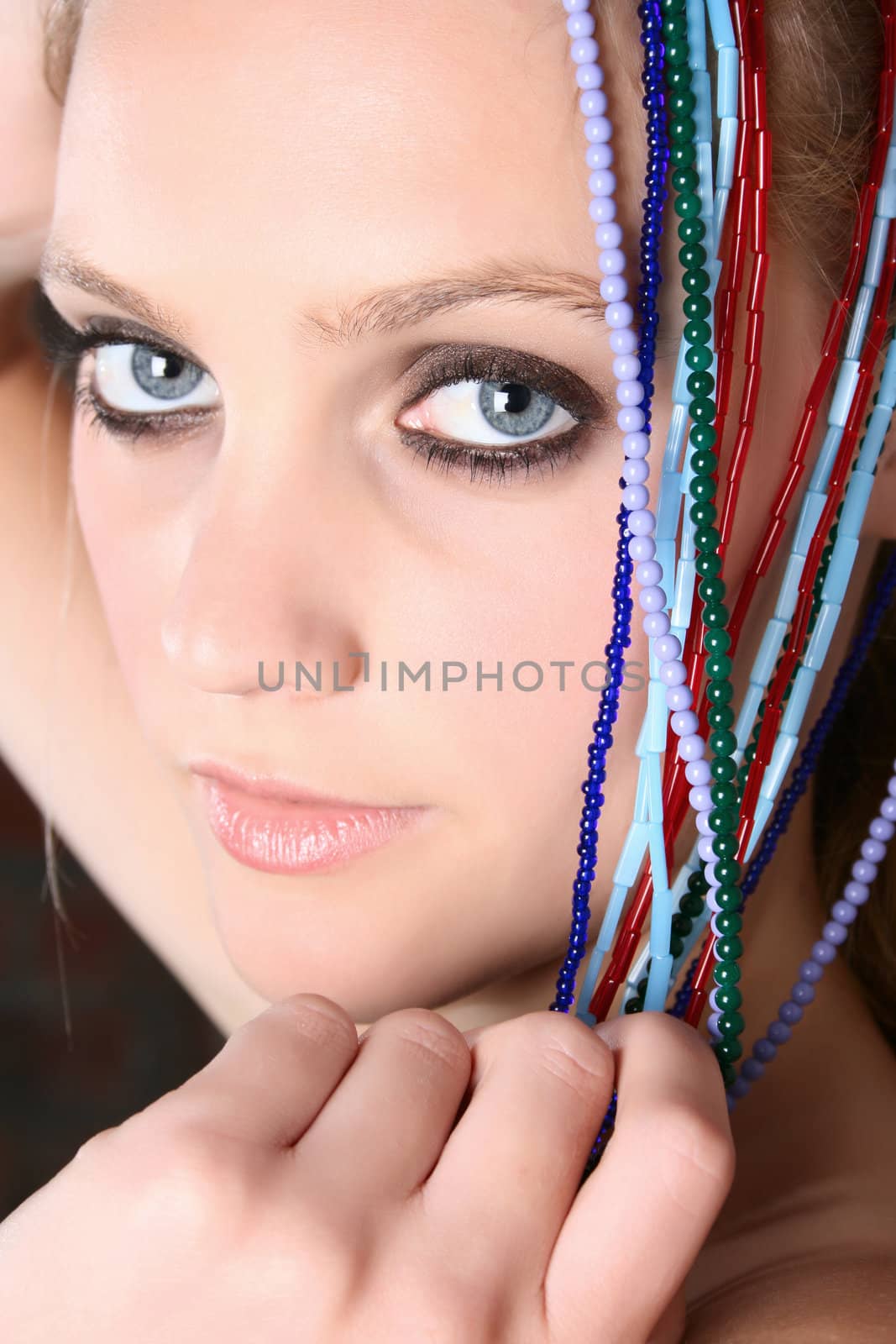 Beautiful young female model with colorful beads