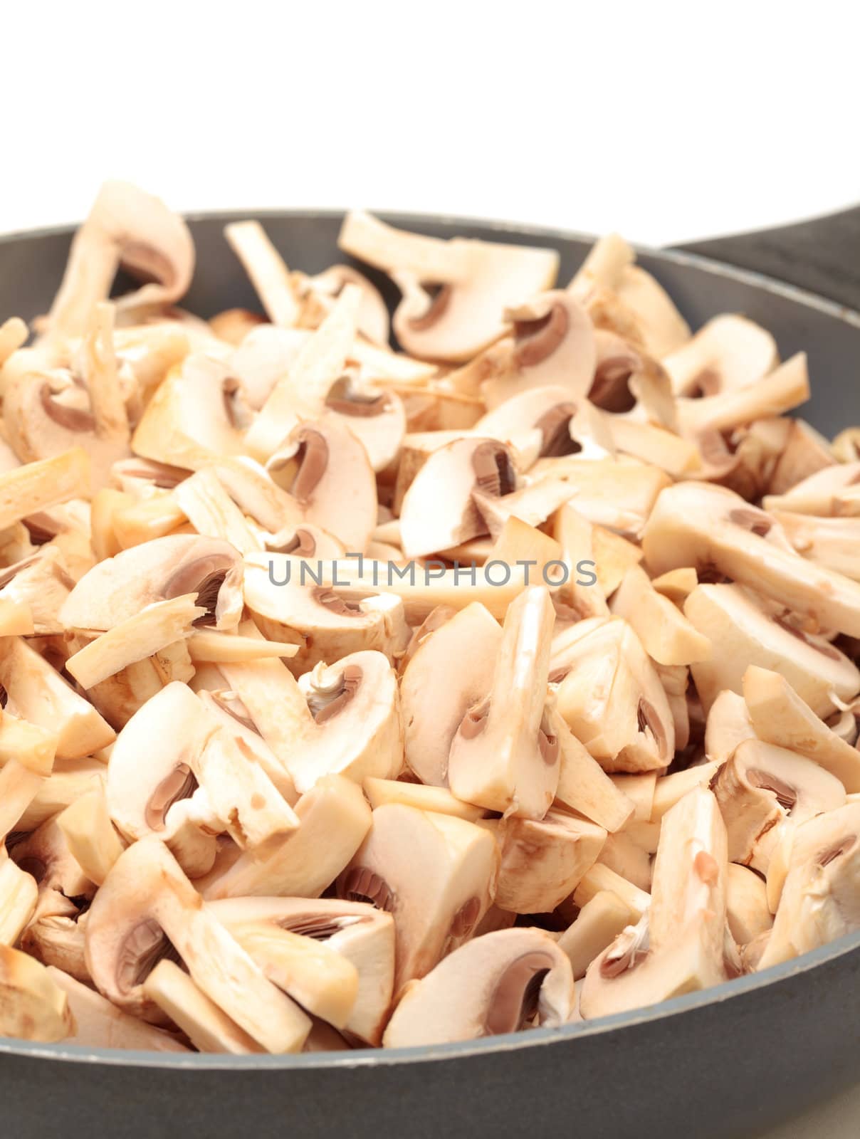 Frying Pan with the sliced Champignons closeup on a white background