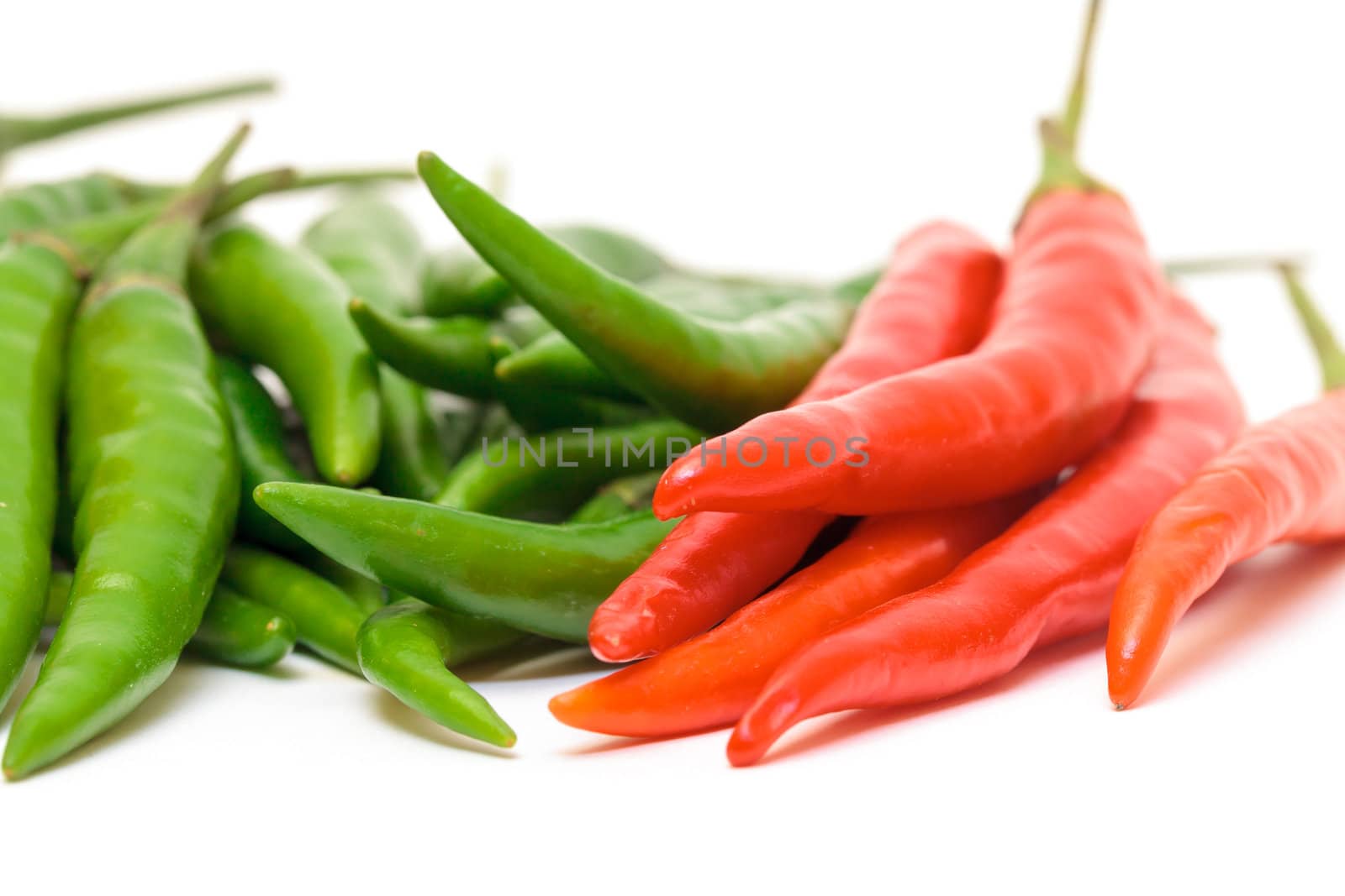 Heap Red and Green Chilli Hot Peppers closeup on white background