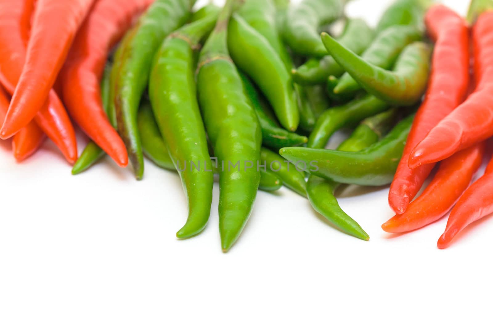 Heap Red and Green Chilli Hot Peppers closeup on white background