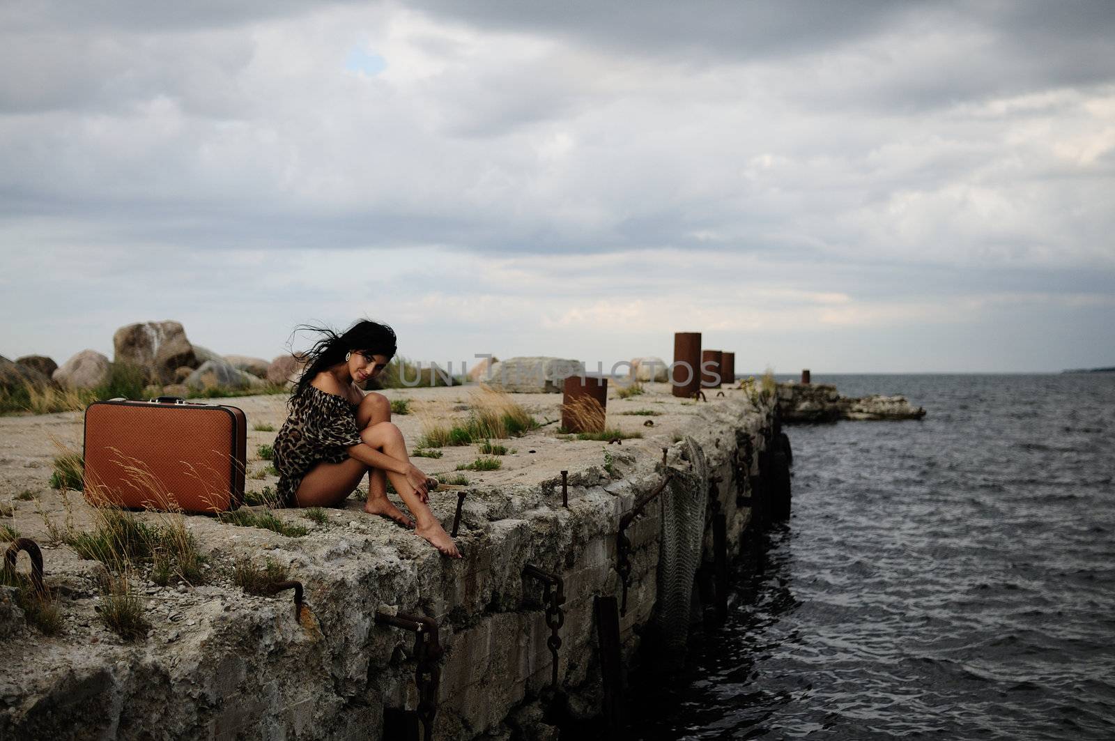 brunette woman sitting at the sea by peterveiler