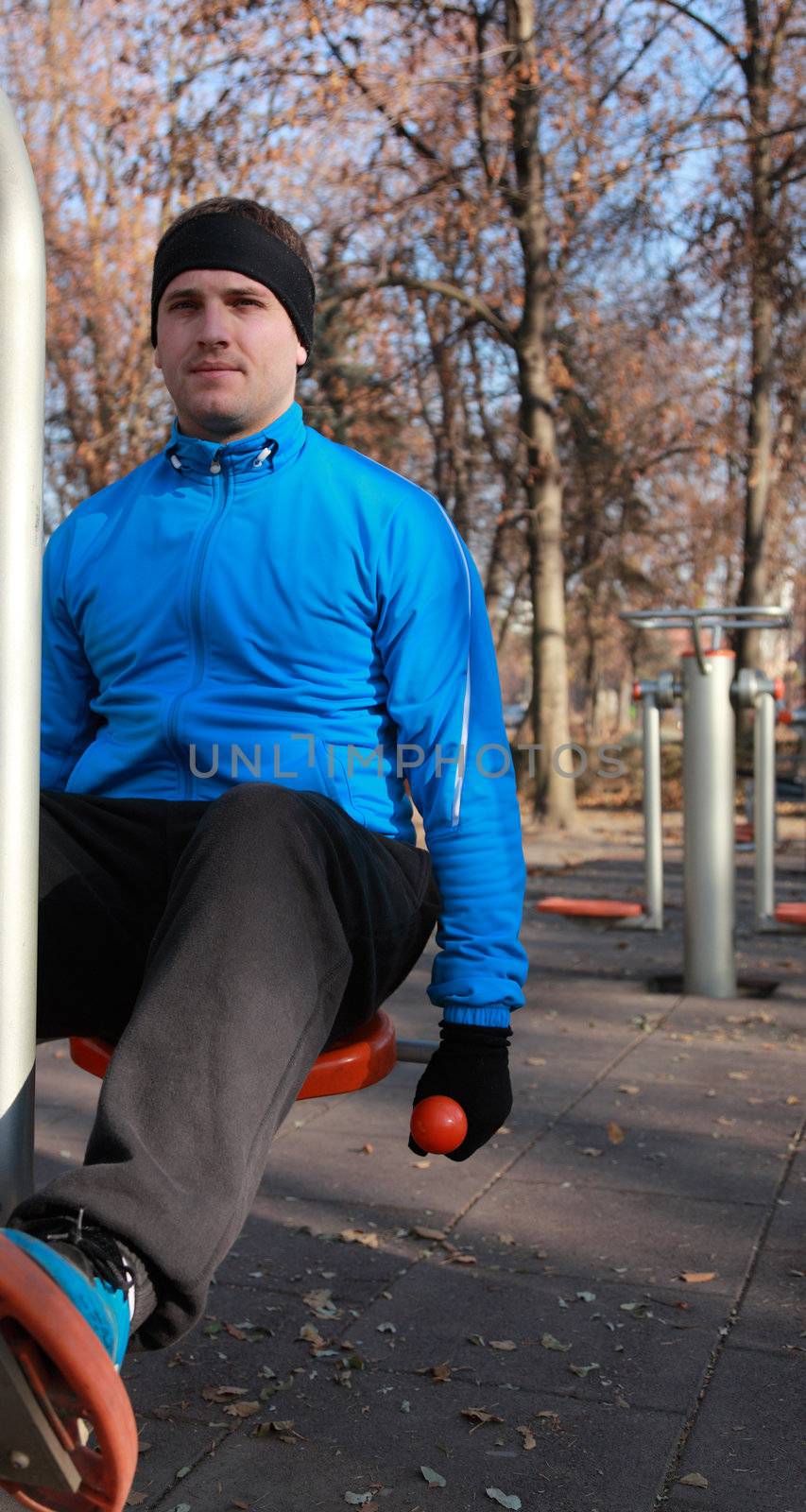 A young man doing exercise outdoors in a public park.