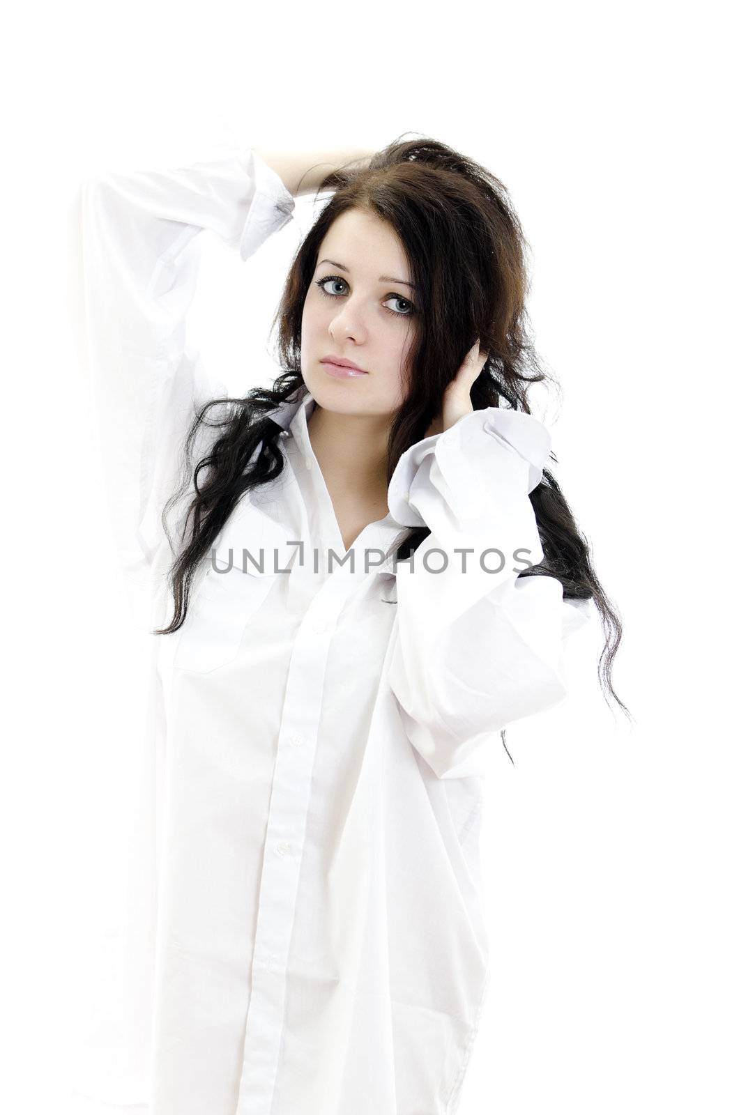 Sensual brunette girl in man's shirt touching her hair. Isolated on white.