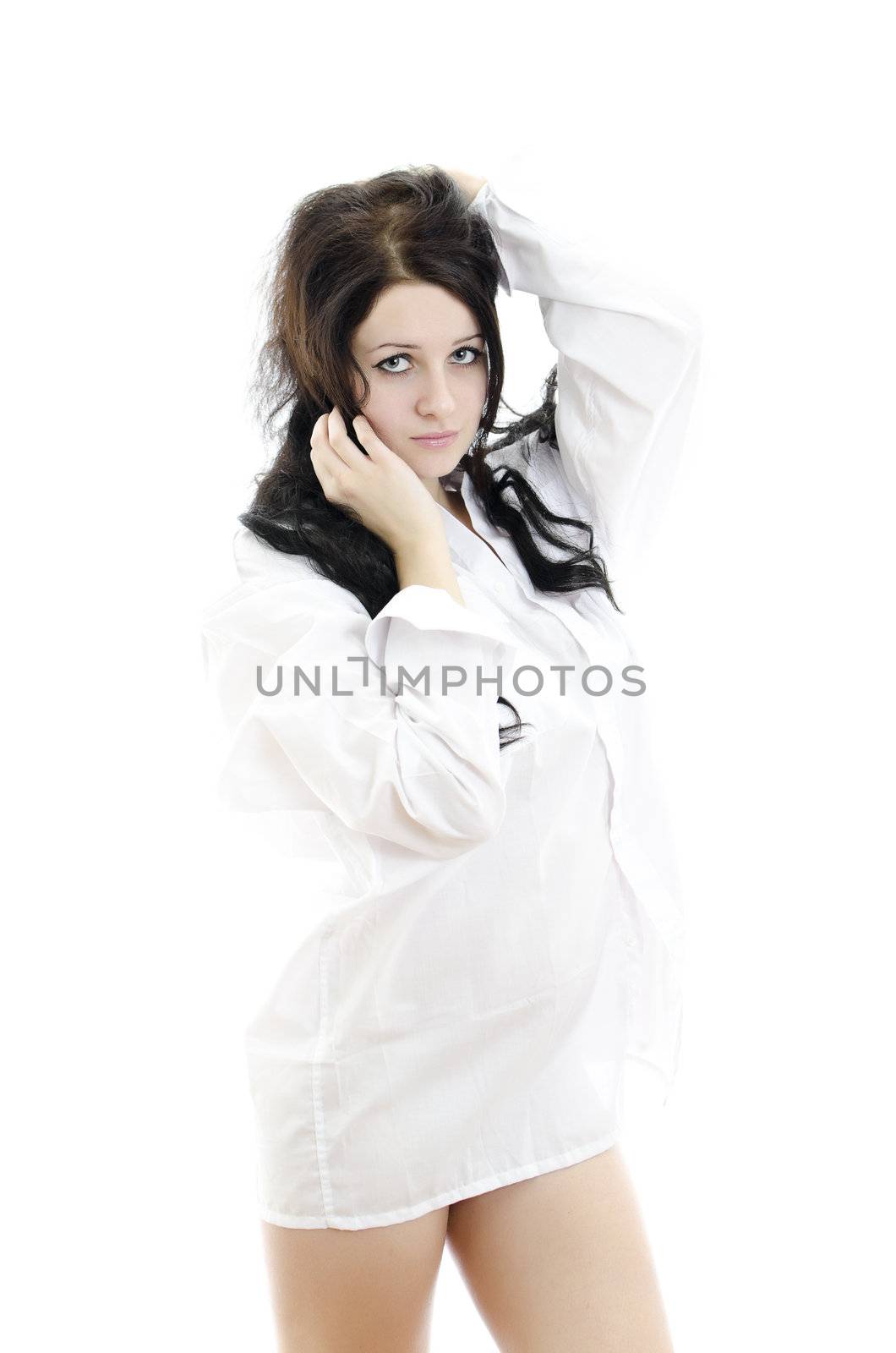 Sensual brunette girl in man's shirt touching her hair. Isolated on white.