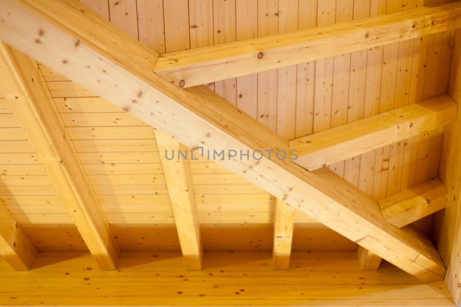 Interior architectural details of a wooden ceiling showing beams and joins extending into a corner
