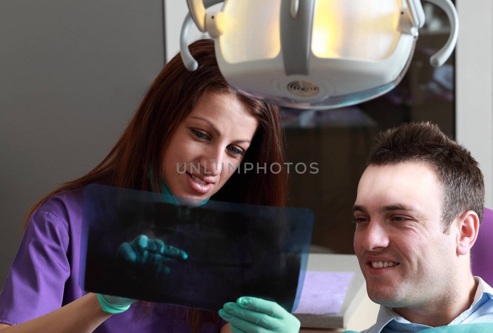 A dentist explaining to the patient a radiography.