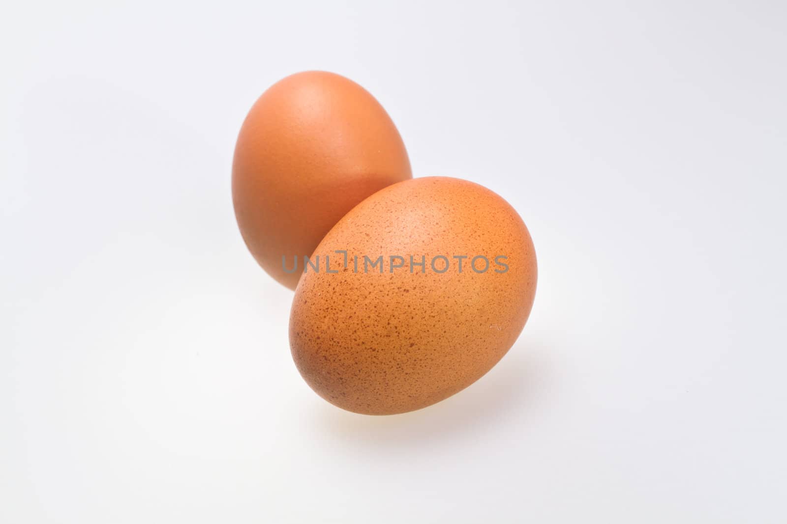 two whole brown eggs isolated on white background