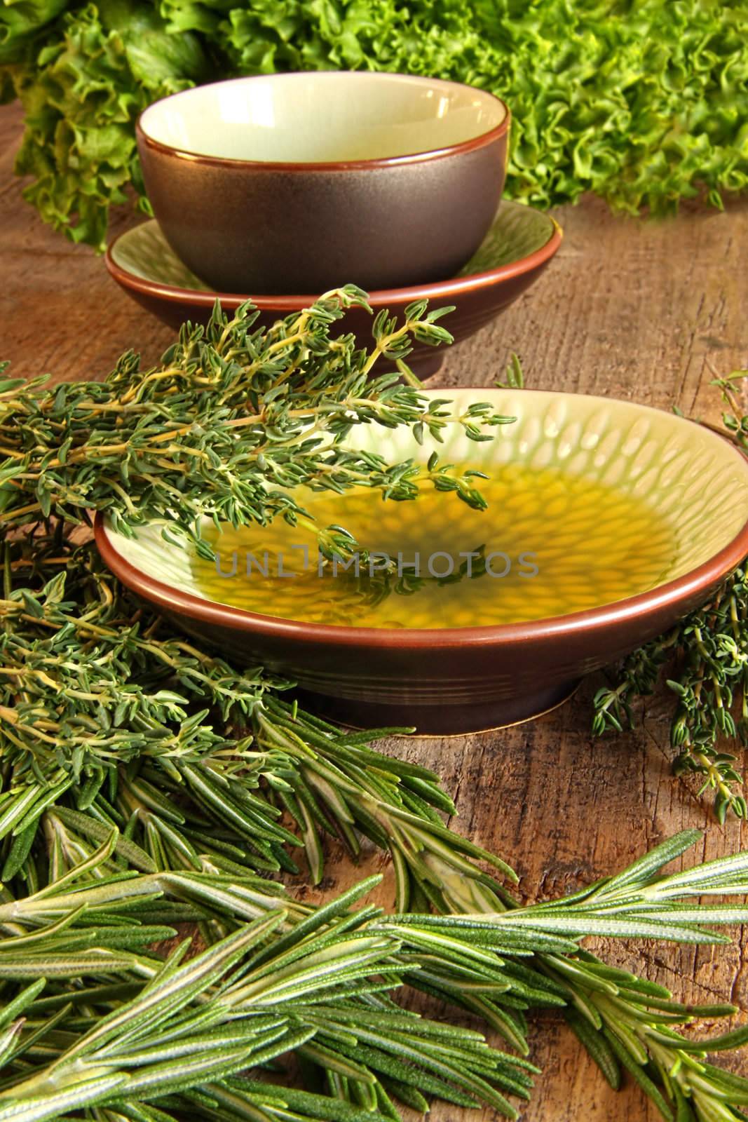 Fresh herbs with olive oil on wooden cutting board 