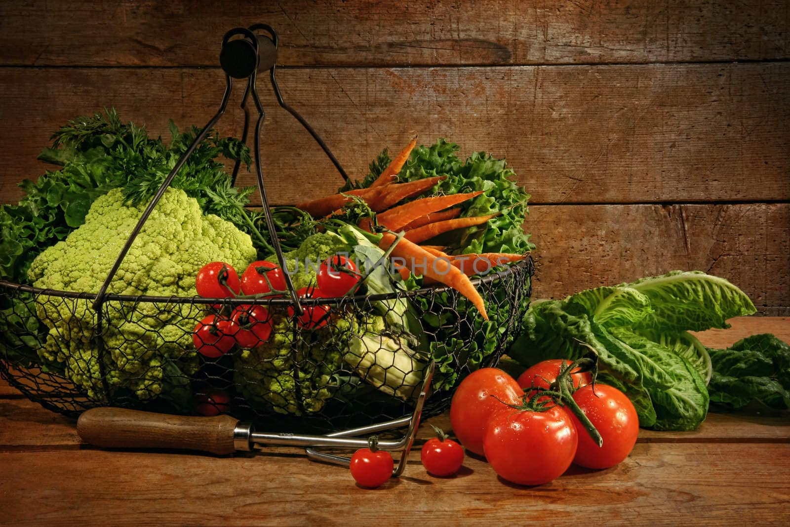 Freshly picked vegetables in basket in wooden table by Sandralise