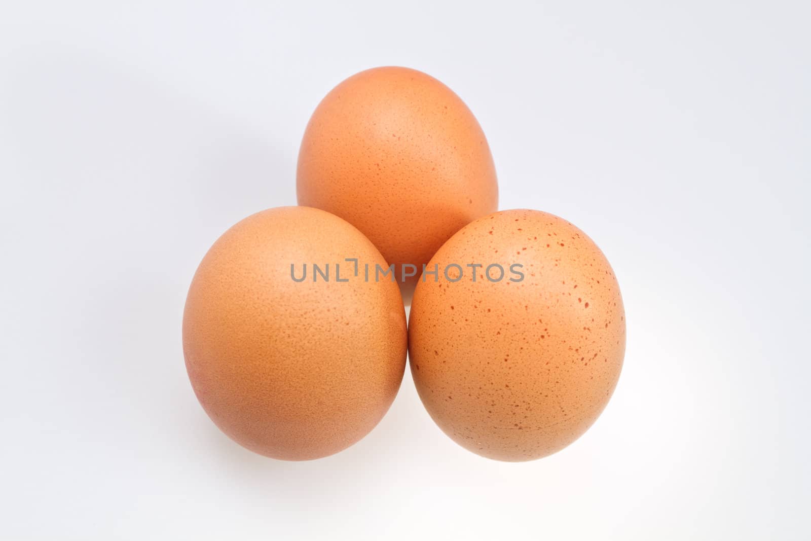 Three brown eggs isolated on white surface