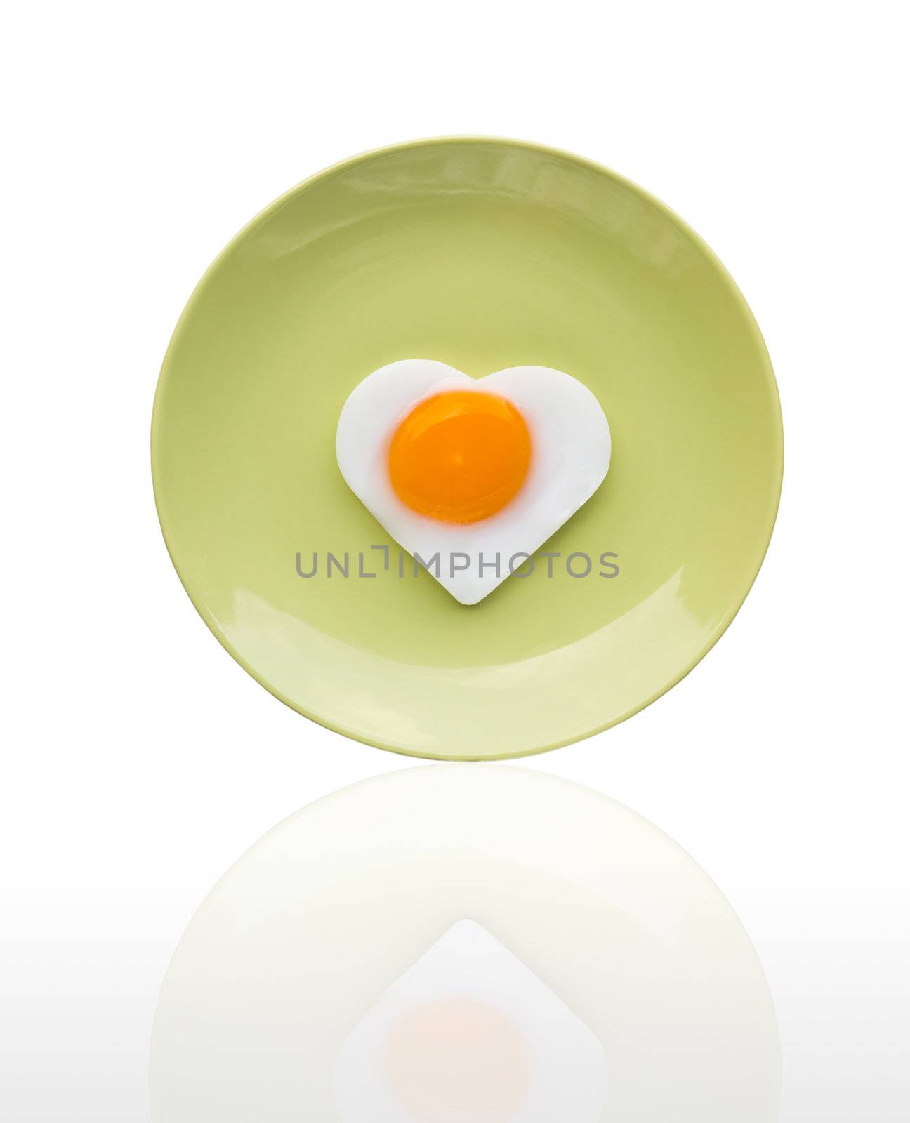 Fried egg like heart on green dish