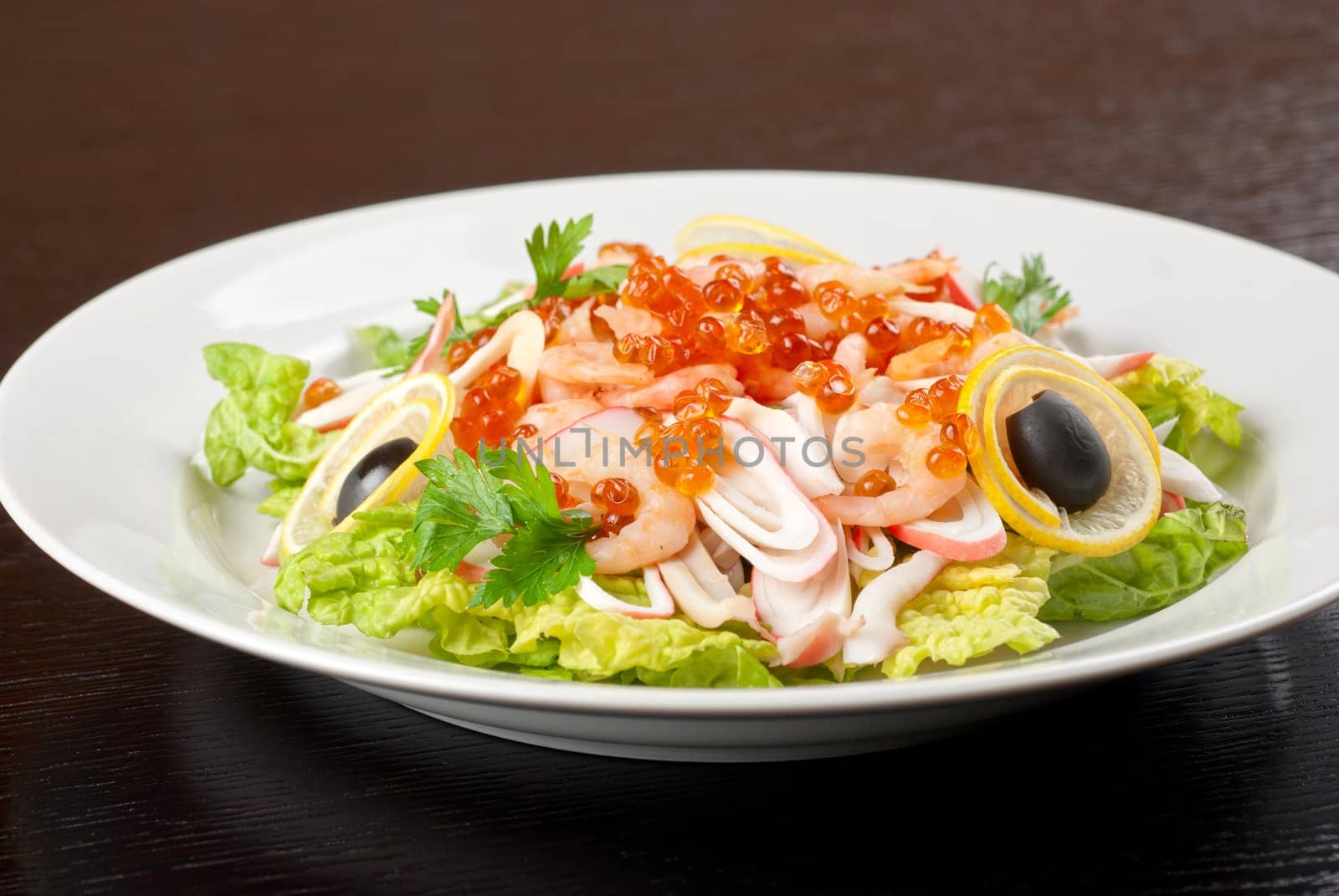 Salad with shrimps, caviar, calamaries, lettuce, lemon and olive