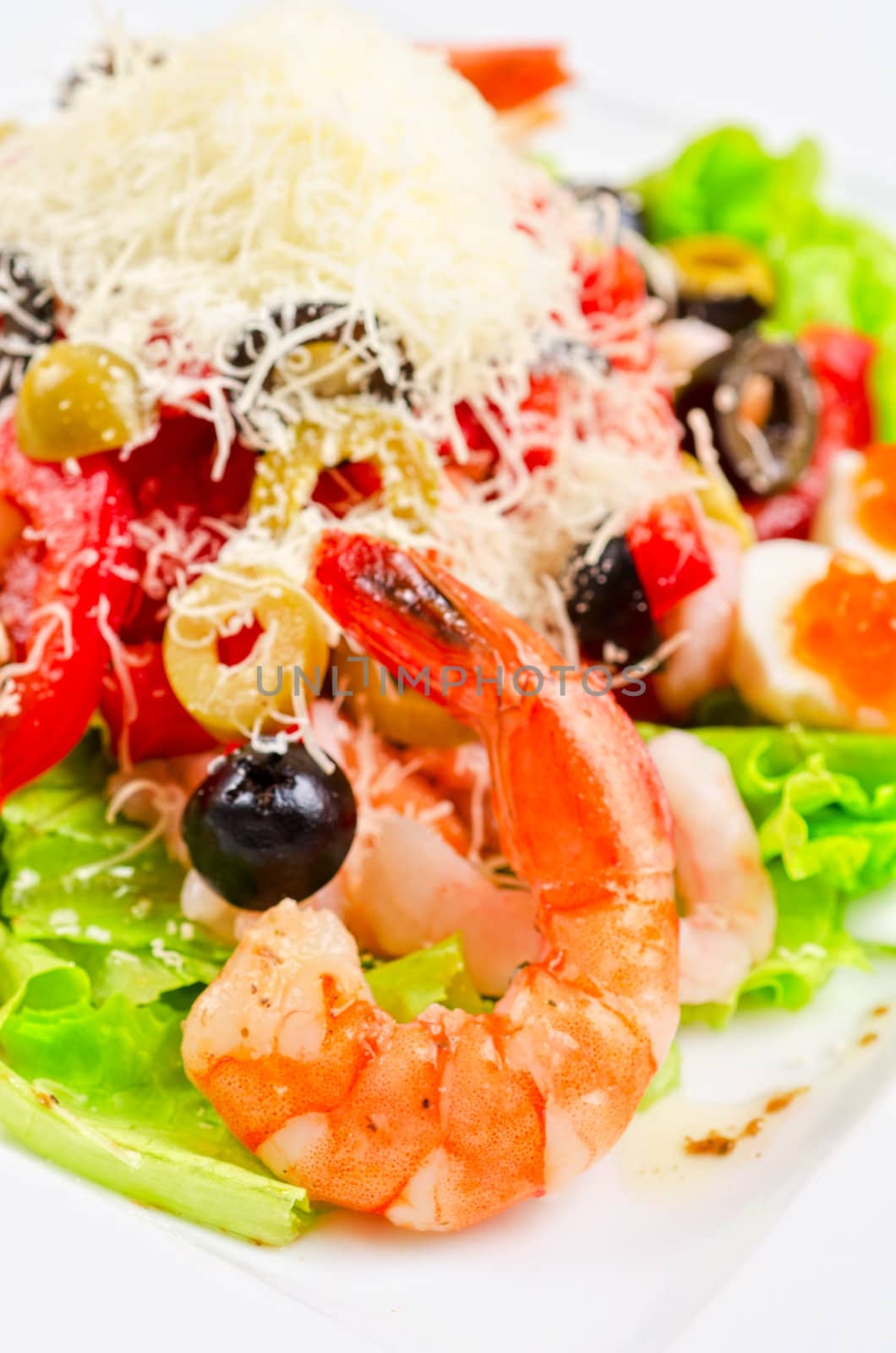 Salad with shrimps, caviar, calamaries, lettuce, olive, tomato and mozzarella